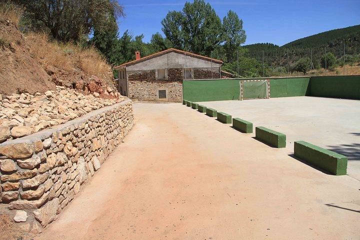 Un muro de mampostería remata el urbanismo en el entorno deportivo de Muriel