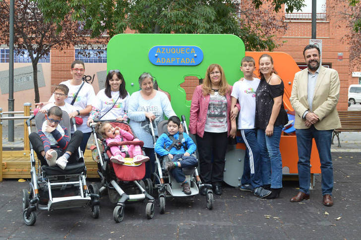 Familias de las asociaciones ADA y Caminando, junto a la concejala de Educación y Cohesión Social y el alcalde, junto a los juegos de la plaza de La Rioja. Fotografía: Álvaro Díaz Villamil/ Ayuntamiento de Azuqueca de Henares